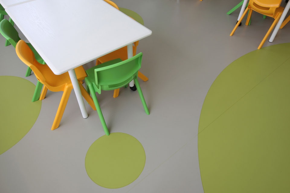 Pardoseala din linoleum, gri cu buline verzi si o masa cu scaune colorate
