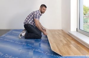 Barbat care monteaza parchet