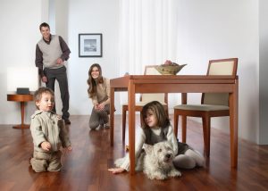 Familie care se joacă în living pe parchetul din lemn de mahon african