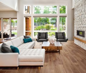 Living spatios si luminos de casa vacanta, cu pardoseala din vinil de culoare maro, cu model de parchet